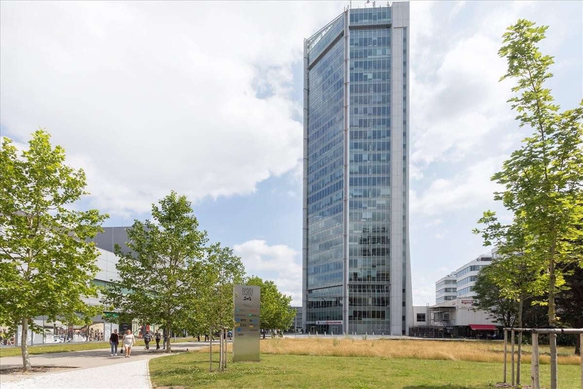 Exterior view of the glass-facade Prague Empiria skyscraper and surrounding park.