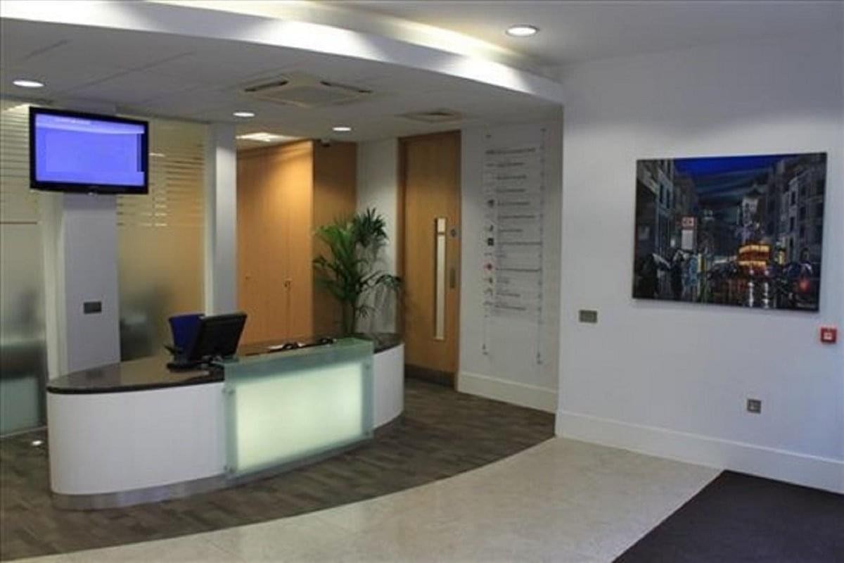 Bright reception desk at Quantum House, 22-24 Red Lion Court featuring a screen and directory wall.