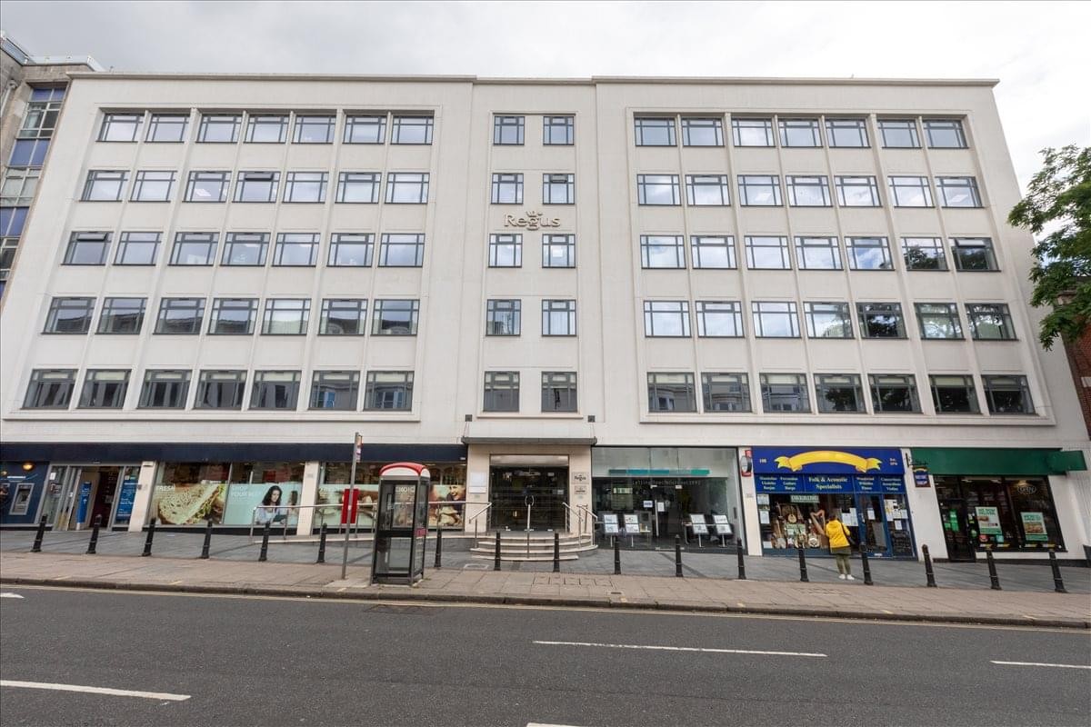Exterior facade of Queensberry House with street-level retail units and a red telephone box.