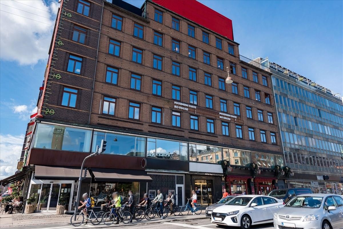 Exterior view of the brick facade and street-level storefronts at Radhuspladsen 16.