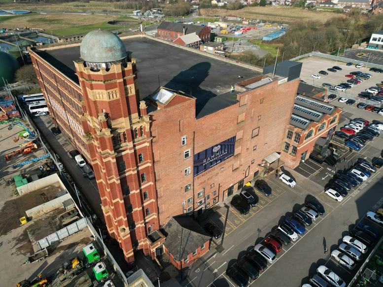 Aerial exterior view of the historic red brick building with its unique domed tower at Ram Mill.