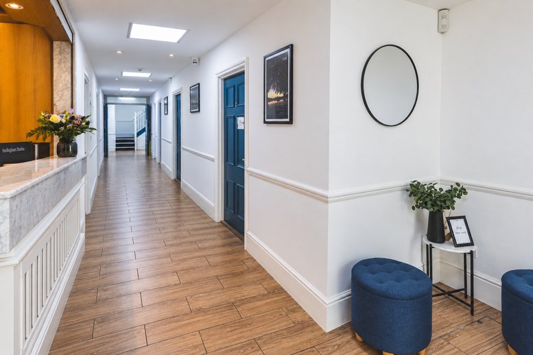 Elegant reception hallway with wood floors and a marble front desk.