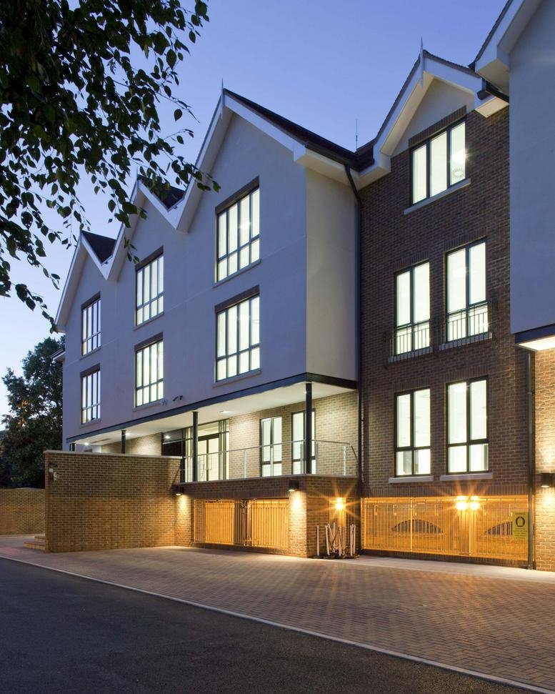 Evening view of the modern brick and white gabled facade at Riverbridge House, Guildford Road.