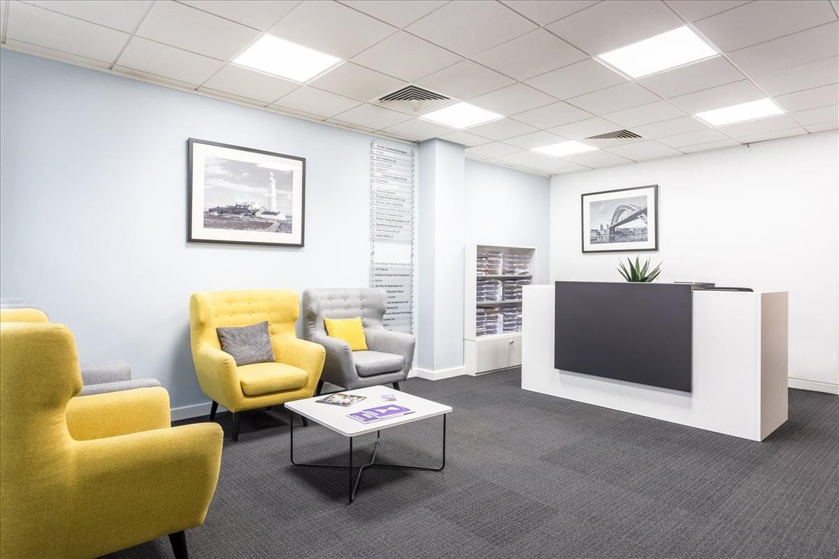 Bright reception area with yellow armchairs and a modern front desk.