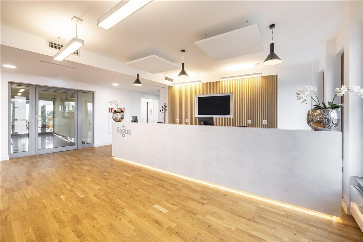 Professional reception desk with a white counter and stylish pendant lighting.