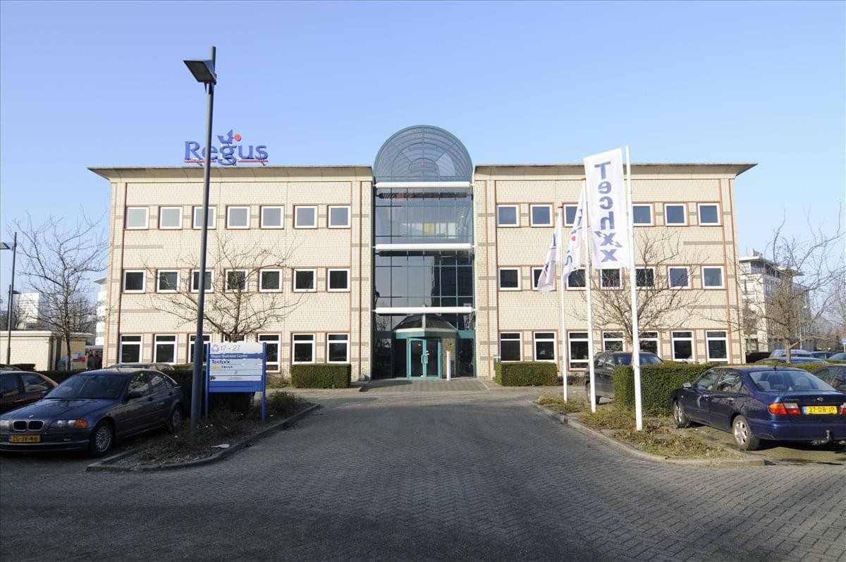 Exterior view of the Schiphol Airport Tetra building featuring a symmetrical facade and glass central entrance.