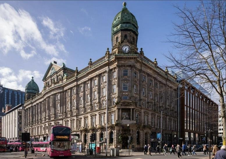 Exterior view of the historic stone facade and corner clock tower of the Scottish Provident Building.