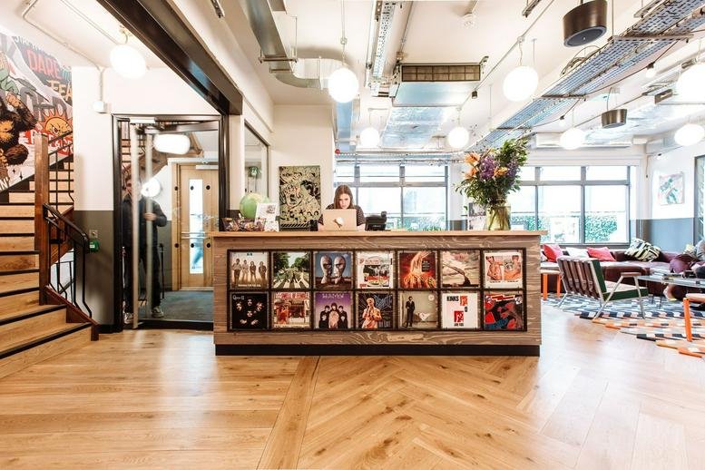 Spacious reception area at Sheraton House featuring a wood-panelled desk decorated with vinyl record covers.