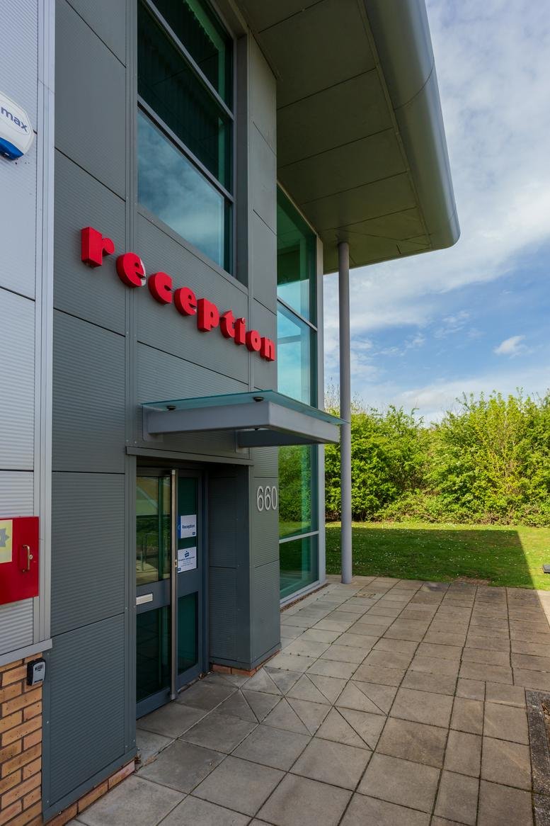 Exterior entrance of Unit 660, Skyline 120 showing grey cladding and red reception signage.
