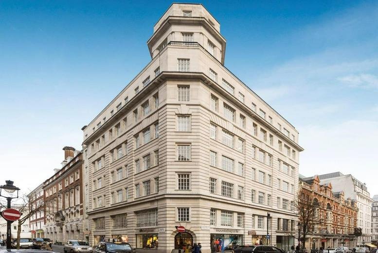 Exterior corner view of Tower House showing its distinctive stone facade and rounded turret under a blue sky.
