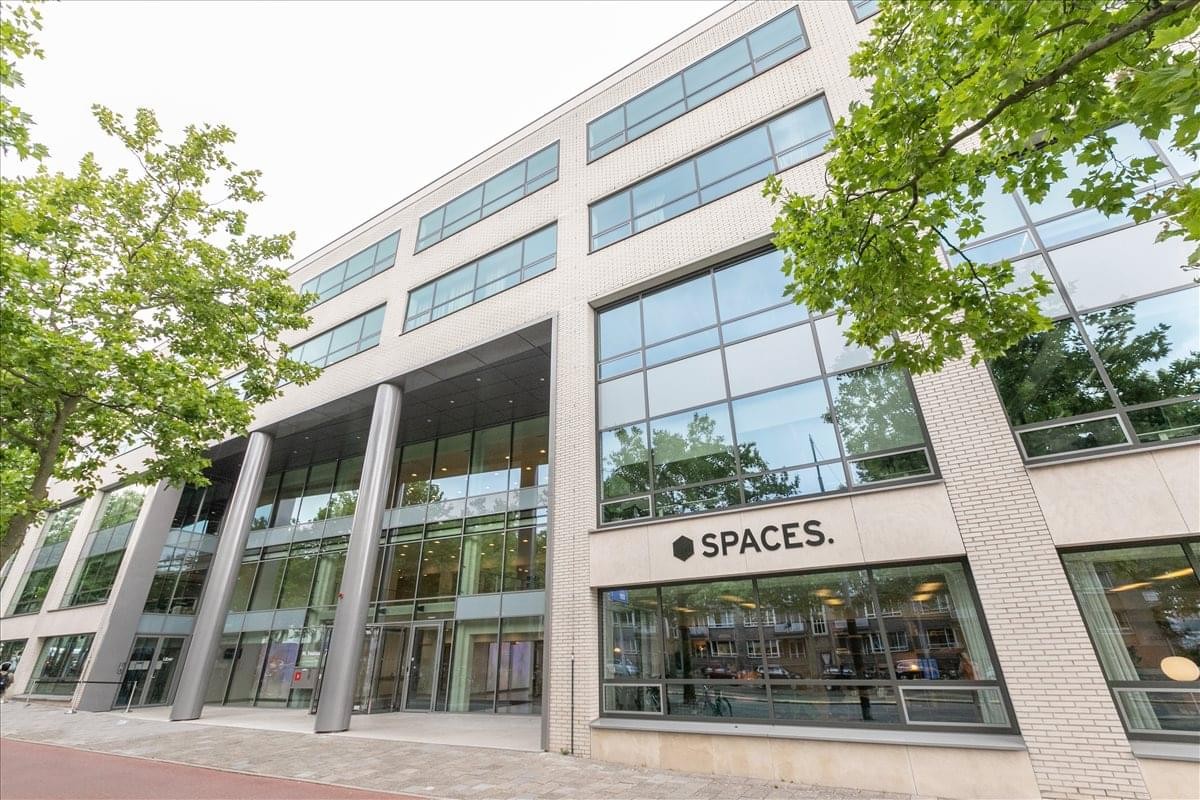 Exterior facade of the modern glass and stone building at Spaces Amstel, Meester Treublaan 7.