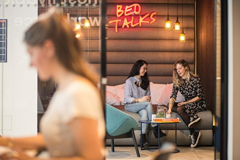 Spacious communal lounge at Sphinxcour 9A, Maastricht, Limburg featuring neon signage and plush seating.