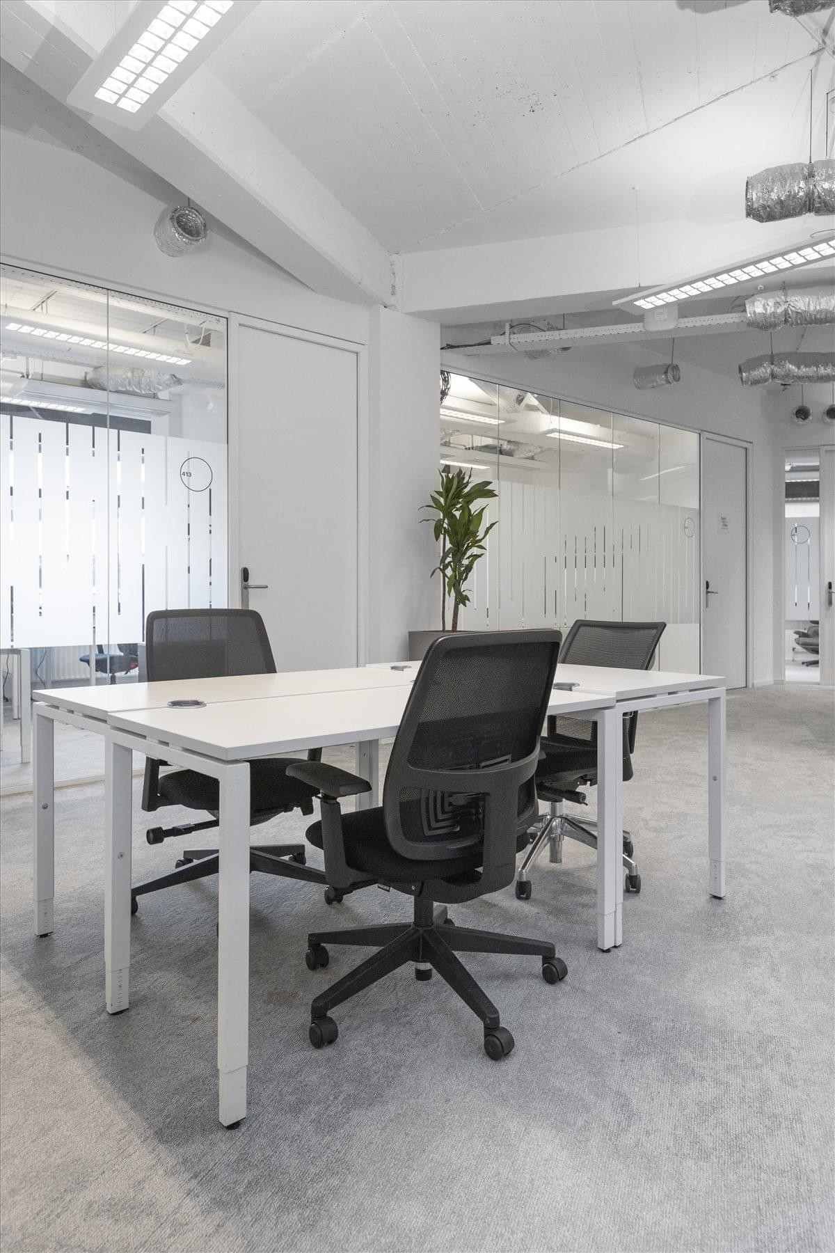 Spacious open-plan workspace at St. Jacobsstraat 123-135 with white desks and black mesh chairs.