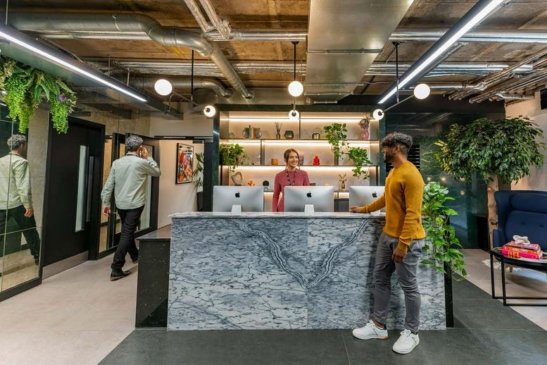A modern reception desk with a marble-patterned front and warm lighting at St. Stephens Green, Dublin, 2.
