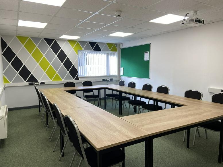 Spacious meeting room at Station Approach, Victoria, Roche, St Austell with a u-shaped table and geometric wall.