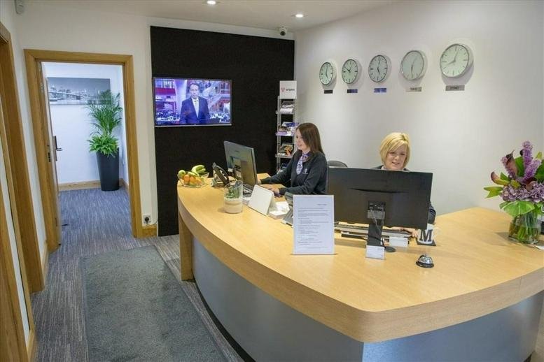 Welcoming reception area at Station Road, Warmley, Bristol, Gloucestershire with wooden desk and world clocks.