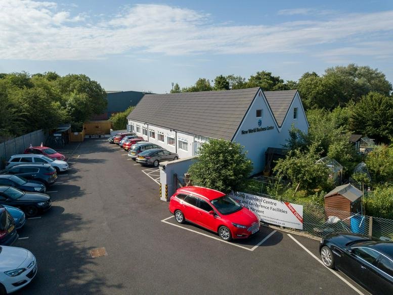 Exterior view of the New World Business Centre with its gabled roof and parking lot.