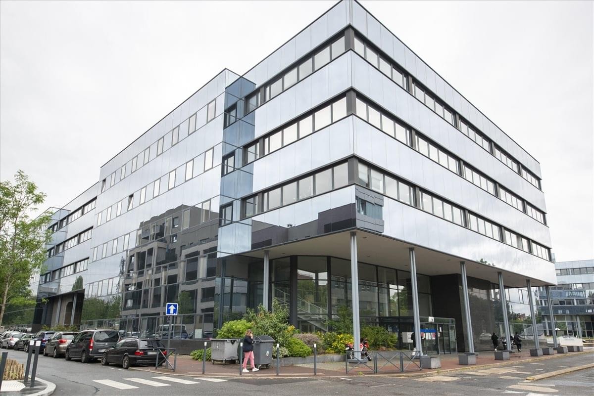 Exterior view of the multi-story glass and metal facade at Stop & Work Cergy.