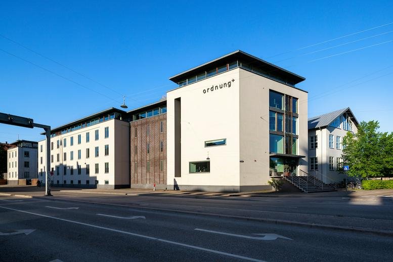 Exterior view of the white facade and entrance of Strandvejen 125, Hellerup.