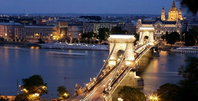 Evening exterior view of Széchenyi István tér 7-8. overlooking the illuminated Chain Bridge.
