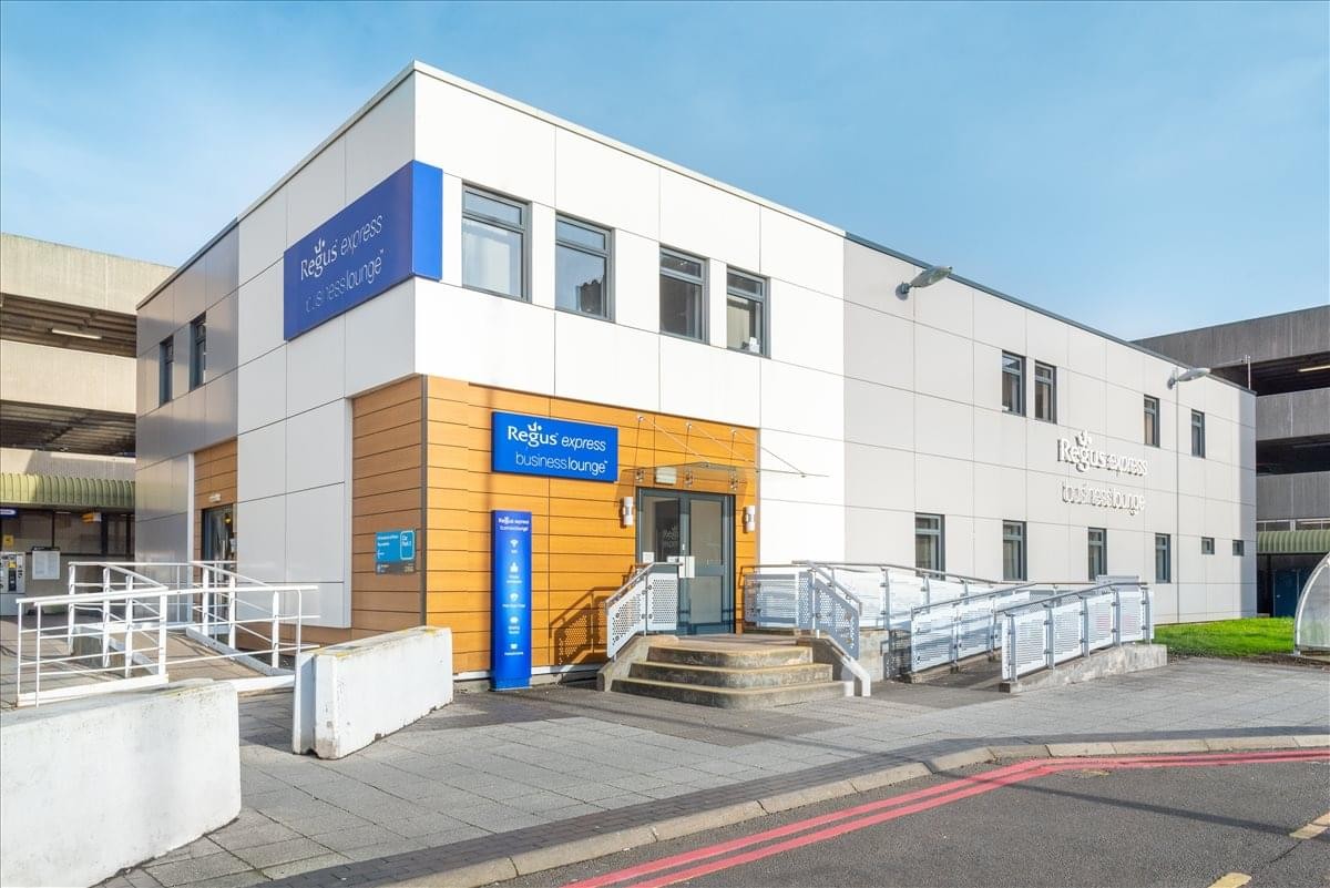 Exterior view of the modern white and wood-paneled Ground Floor at The Comet Building, Birmingham Airport, Regus Express.
