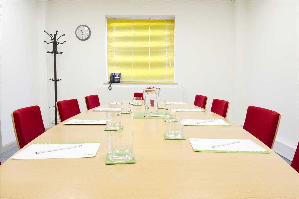 Meeting room at The Havens, Ransomes Europark featuring red chairs and a large wooden table.