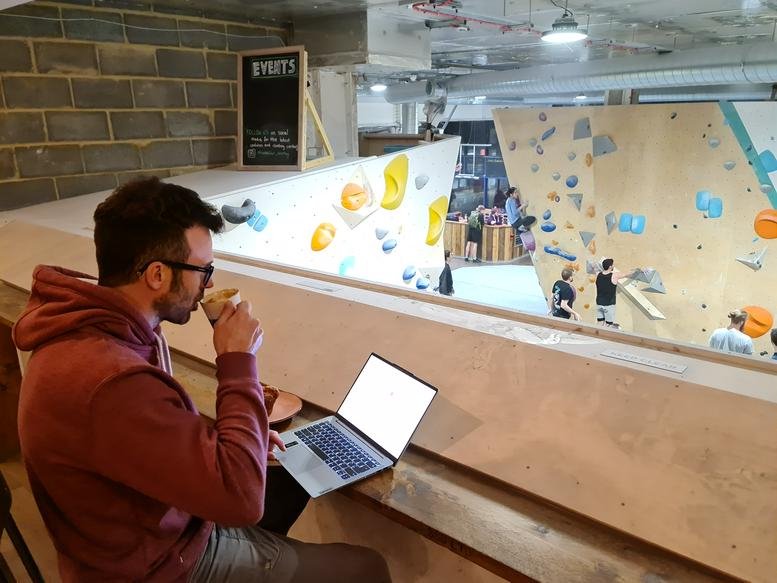 Bright communal workspace at Rhino Boulder, Unit 6 & 7, The Mall, Bromley, London overlooking a climbing gym.