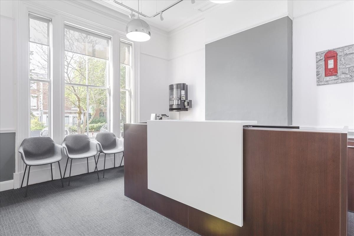 Reception area at The Quadrant Business Centre featuring a wood-fronted desk and seating.