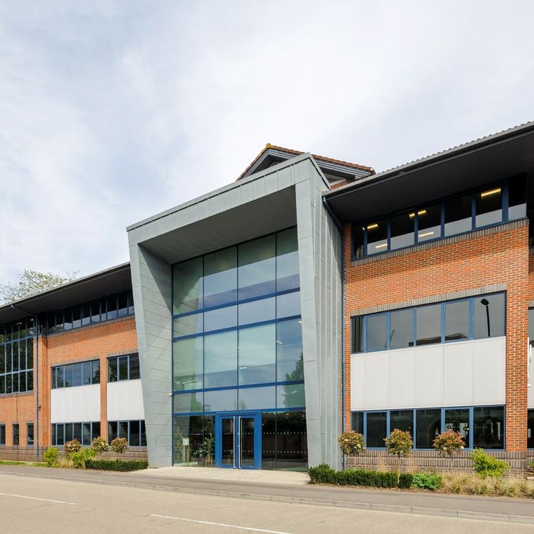 Modern brick and glass facade of Threefield House with a prominent grey stone entrance.