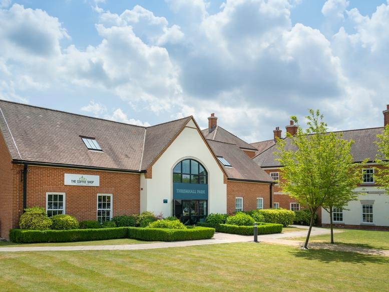 Exterior view of the brick-built Thremhall Park, The Priory building under a blue sky.