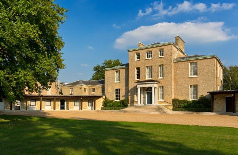 Exterior view of the stately stone facade and grounds at Milton Hall Cambridge.