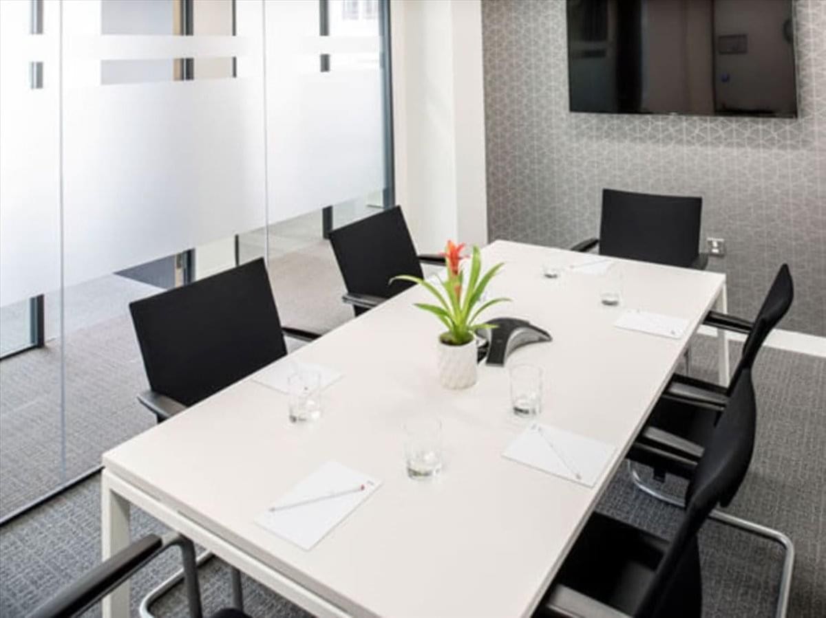 A professional meeting room at Palazzo Valadier, Piazza del Popolo 18 with a white table and potted plant.