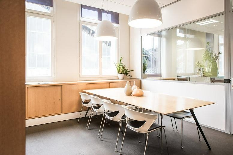 Meeting room at Tour de l’Horloge, 4 Place Louis Armand with light wood table and pendant lamps.