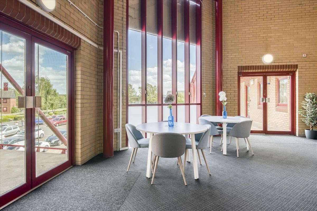 Communal area with large windows and round tables