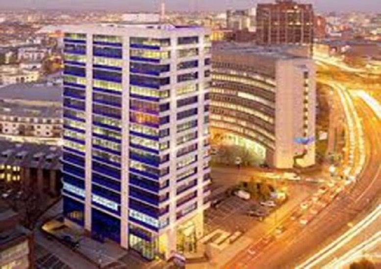 Exterior view of the Cobalt House high-rise building and surrounding city at dusk.