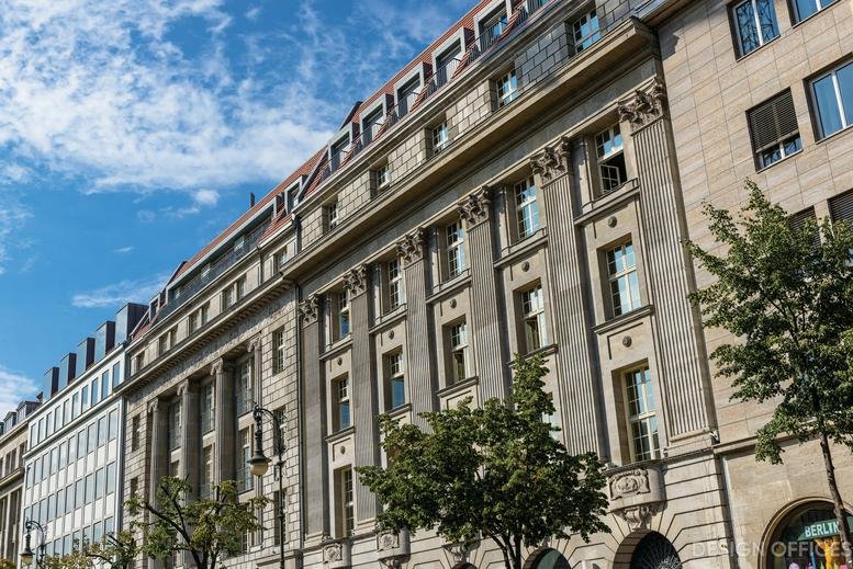 Classic stone facade of the historic Unter den Linden 26-30 building against a blue sky.