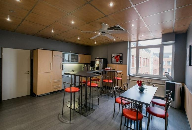 Spacious communal kitchen and lounge at Vahrenwalder Straße 269 A with high-top tables and red bar stools.