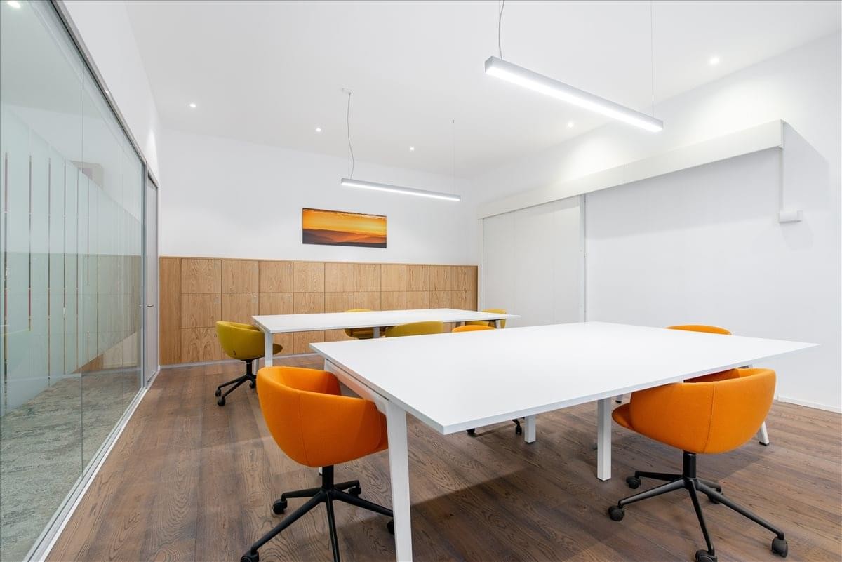 Modern coworking space at Central Rome, Via Antonio Salandra 18 with orange chairs and wooden flooring.