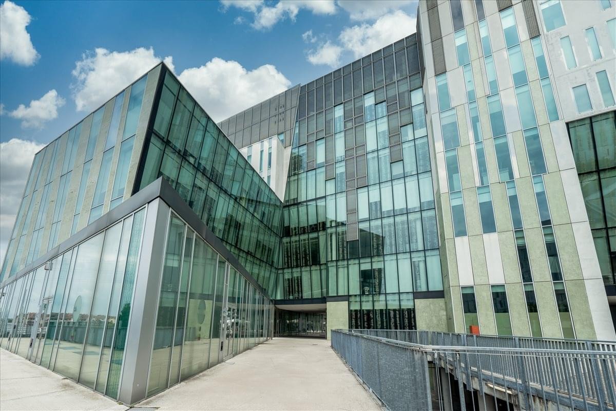 Exterior view of the modern glass-facade at Via del Bosco Rinnovato 6, Building U7.