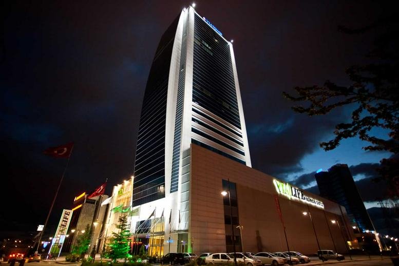 Exterior view of the Via Flat İş merkezi building illuminated at night with street-level lighting.