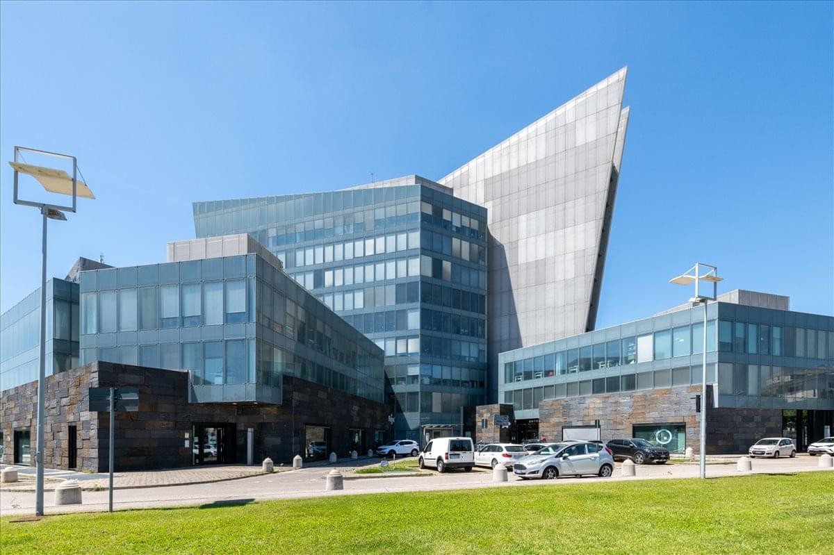 Exterior view of the contemporary glass and stone building at Via Francia 21/C.