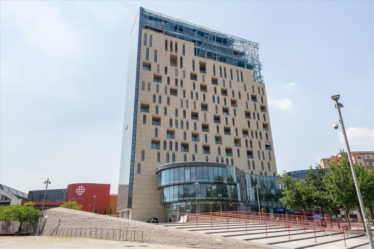 Exterior view of the modern Skyline 18 building with its glass facade and light stone accents.