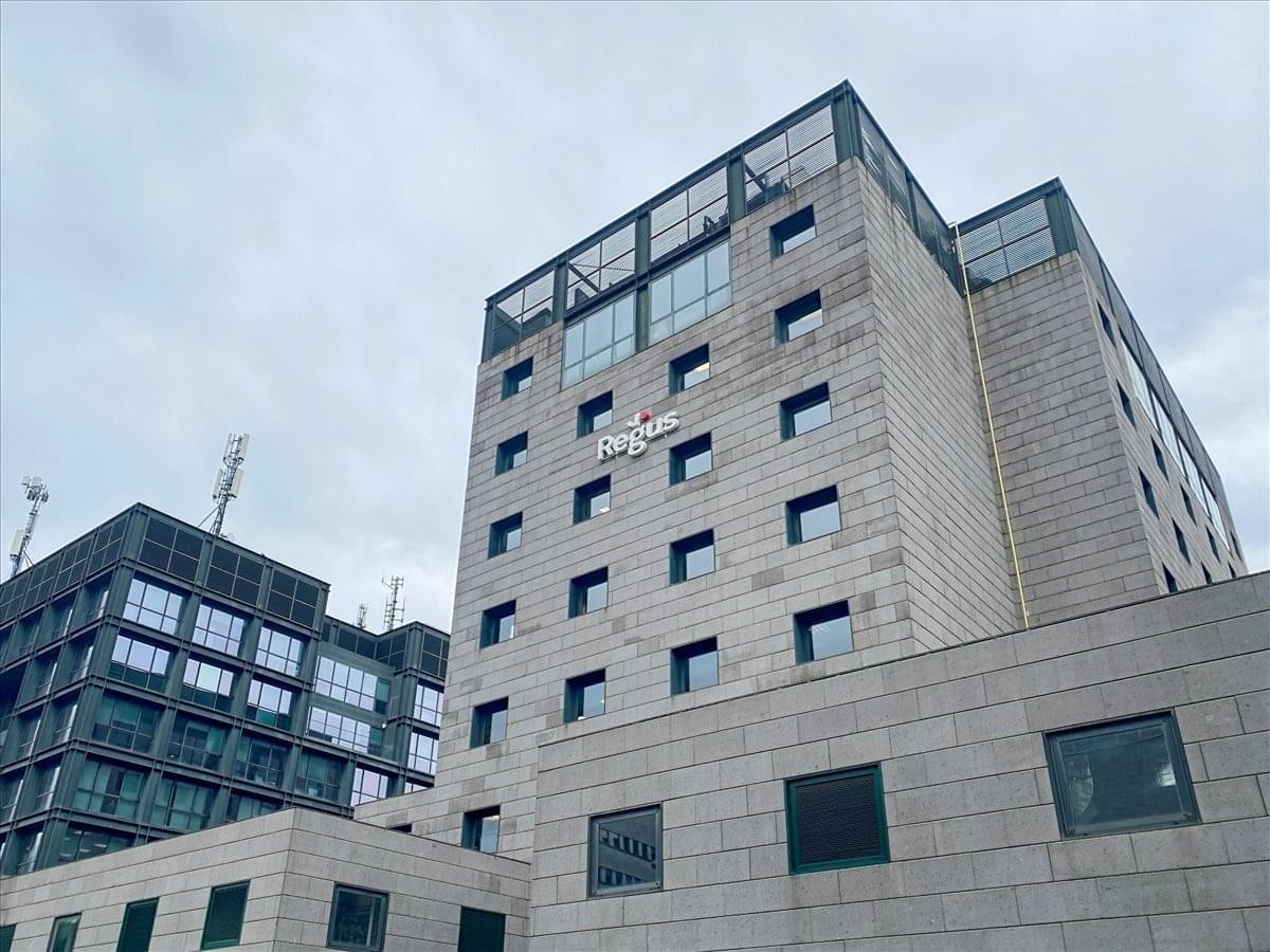 Exterior view of the contemporary stone and glass office building at Via Libero Temolo 4, Milan.