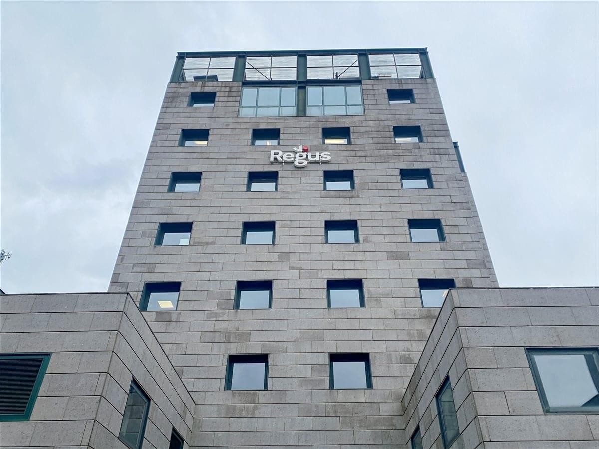 Exterior view of the modern stone-facade building at Via Libero Temolo 4, Milan.