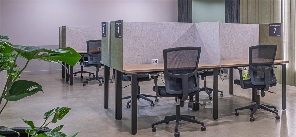 Modern exterior view of the La Stampa building at Via Lugaro 15 with large glass windows and light stone facade.