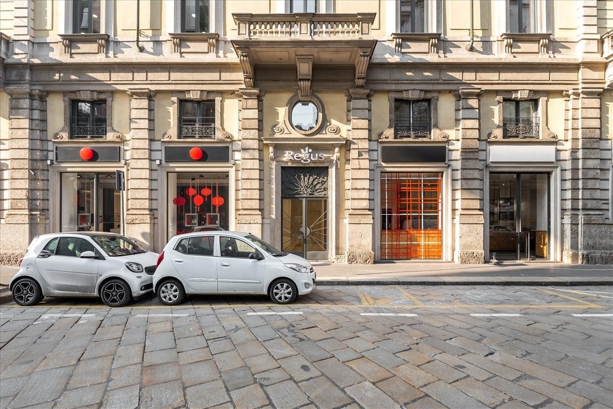 Grand historic stone exterior of the building at Via Mengoni 4 with traditional architecture.