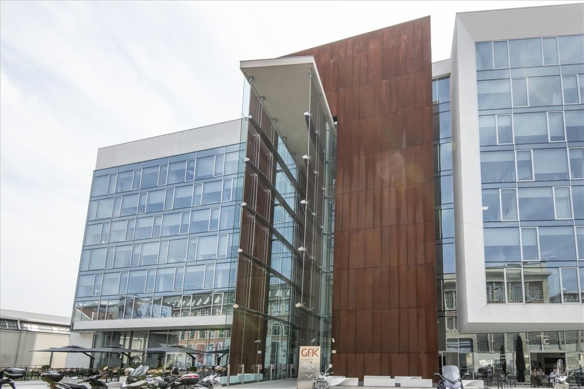 Exterior view of the modern glass and weathered steel facade at Via Tortona 33.