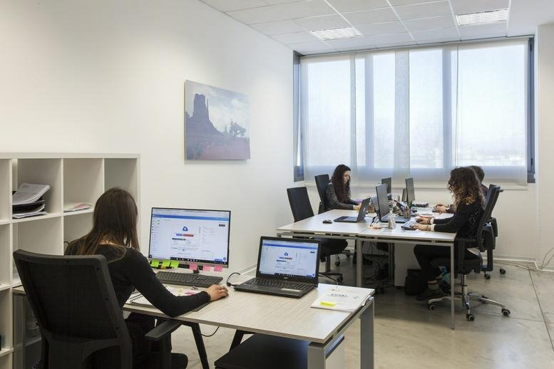 Open-plan office at Via Zamenhof 817, Vicenza, Italy with desks, computers, and natural light.