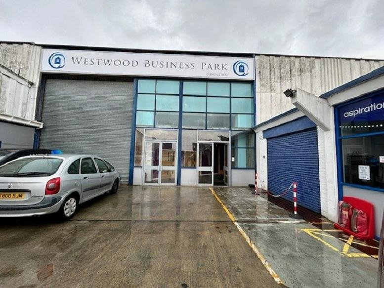 Exterior view of the entrance to Westwood Industrial Estate with a silver car parked in front.