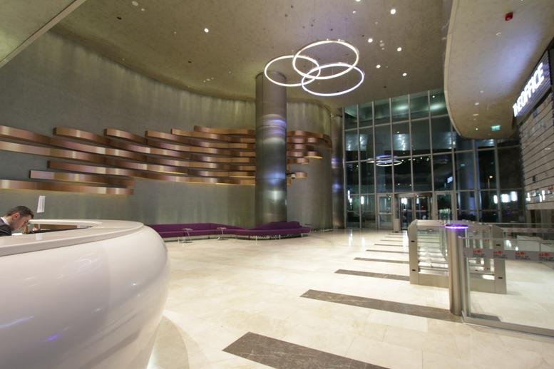 Spacious reception lobby featuring a curved white desk and modern ring pendant lighting.